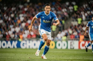 Joueur de football professionnel en pleine course sur un terrain de stade lors d'un match officiel
